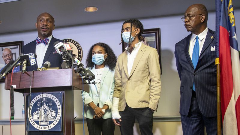 Attorney Mawuli Mel Davis (left) speaks on behalf of Taniyah Pilgrim (second from left) and Messiah Young (second from right) during a press conference by the Fulton County District Attorney's Office in Atlanta, Monday, June 2, 2020. District Attorney Paul Howard (right) announced criminal charges against six Atlanta police officers involved the arrest of Pilgrim and Young.  Davis is representing  Young.