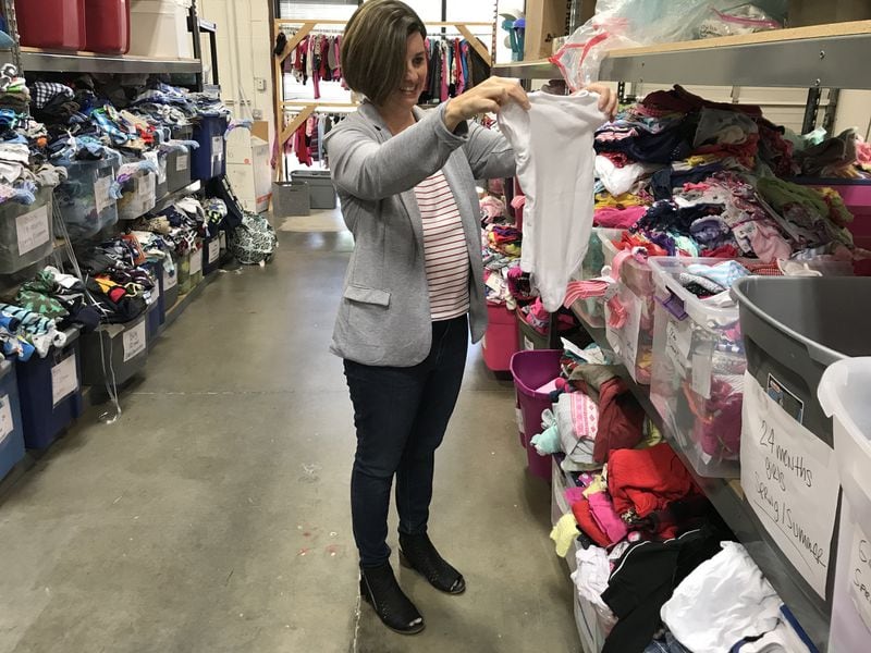Helping Mamas CEO Jamie Lackey sorts clothing donations at the nonprofit’s Norcross warehouse. CONTRIBUTED