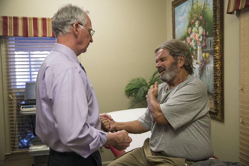10/24/2019 — Augusta, Georgia — Patient Tony Bernhardt of Augusta, winces in pain as Dr. John Downey looks after the pain in his shoulder during his first visit to the Royal Pain Center in Augusta, Thursday, October 24, 2019. Bernhardt, who is looking for alternatives to surgery, was referred to Dr. Downey by the local Veterans Affairs hospital. (Alyssa Pointer/Atlanta Journal Constitution)