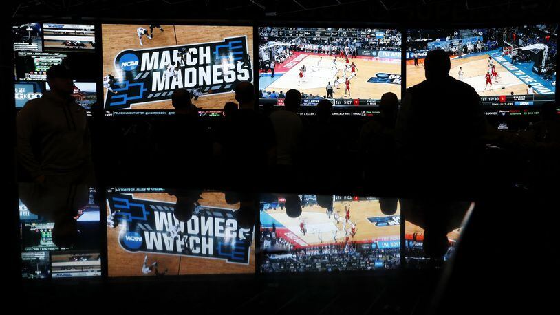 People watch coverage of the first round of the NCAA college basketball tournament at the Westgate Superbook sports book in Las Vegas. The Supreme Court has struck down a federal law that bars gambling on baseball, basketball, football and other sports in most states, giving states the go-ahead to legalize betting on sports. (AP Photo/John Locher)