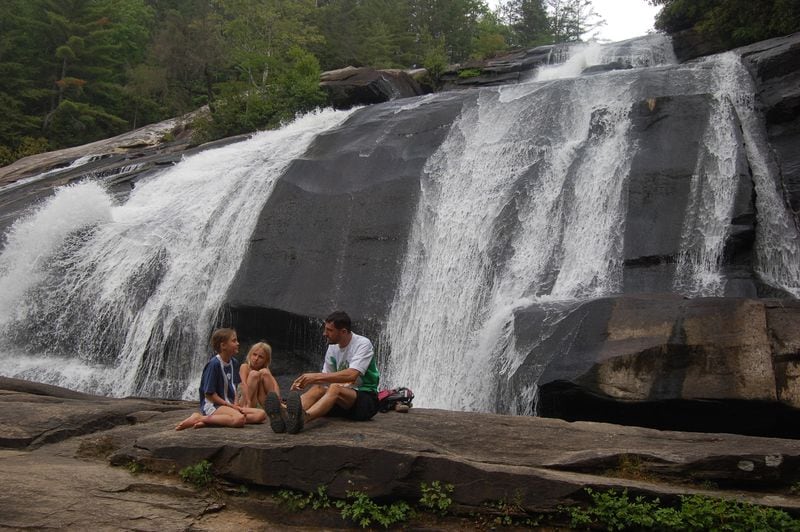 Jonathan Vess of Asheville, N.C., basks in the mist of High Falls in DuPont State Forest along with his daughter, Sophia, 9 (left), and her friend, Hyla Johnson, 8.. Photo Credit: Jack Horan.