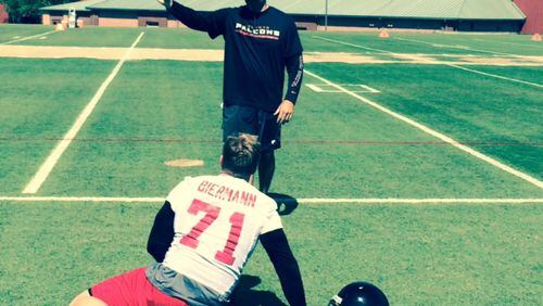 Outside linebacker/defensive end Kroy Biermann stretching before an OTA practice. Can he make it back from a ruptured achilles tendon? (By D. Orlando Ledbetter/dledbetter@ajc.com)