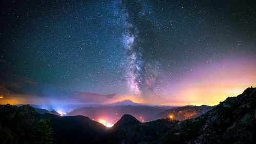 A photography Our Earth In Focus captured an intense scene from Snoqualmie Pass with Mount Rainier, the Milky Way, and what appears to be Washington wildfires burning in the distance.
