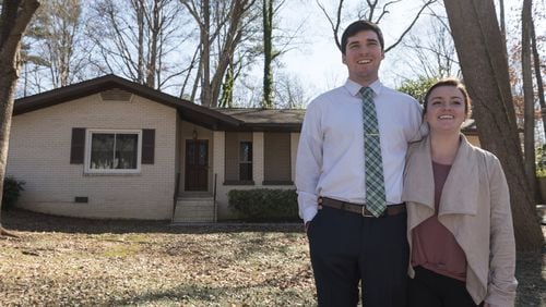 Michael Fox and his wife Erica Fox outside their home in Decatur. The couple bought their home after a sometimes frustrating search in a market of rising prices and short supply. Now they are seeing its value rise and are happy with their decision. (DAVID BARNES / DAVID.BARNES@AJC.COM)