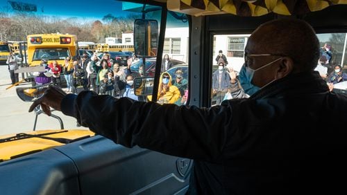 Charles Brown takes a victory lap through the Atlanta Public Schools bus facility on Friday, Dec. 18, 2020, as his coworkers line the lot in honor of his retirement after 32 years of driving. Ben Gray for the Atlanta Journal-Constitution