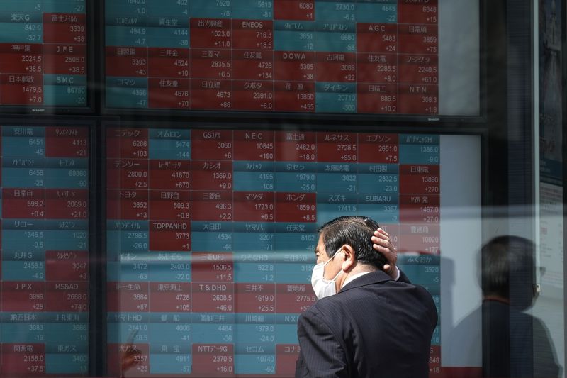 FILE - A person looks at an electronic stock board showing Japan's stock princes at a securities firm Tuesday, April 2, 2024, in Tokyo. Asian shares mostly declined Friday, April 5, after a U.S. Federal Reserve official said the central bank might not deliver any of the interest rate cuts that Wall Street has been banking on this year, citing concerns about inflation. (AP Photo/Eugene Hoshiko, File)