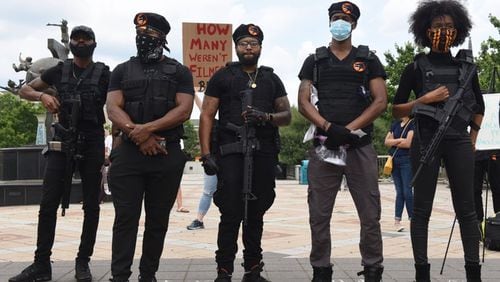 Spiike G. (center) and Whitney Oni (far right) line up with their friends at a protest Wednesday, June 3, 2020, on the Decatur Square. The group dressed as Black Panthers, but they are models and actors. RYON HORNE / AJC