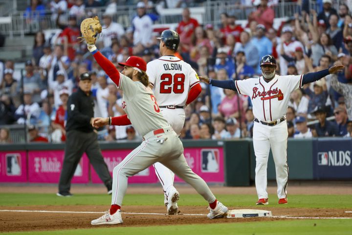 Atlanta Braves’ Matt Olson (28) beats out a throw to Philadelphia Phillies’ Bryce Harper (3) on a fielding error during the second inning of the NLDS Game 2 In Atlanta on Monday, Oct. 9, 2023.   (Miguel Martinez / Miguel.Martinezjimenez@ajc.com)