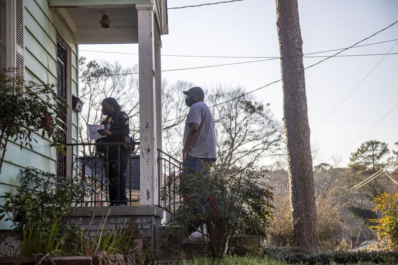Officers and community members canvassed the neighborhood in February following David Mack's death. So far, nobody has come forward with any information. (Alyssa Pointer / Alyssa.Pointer@ajc.com)