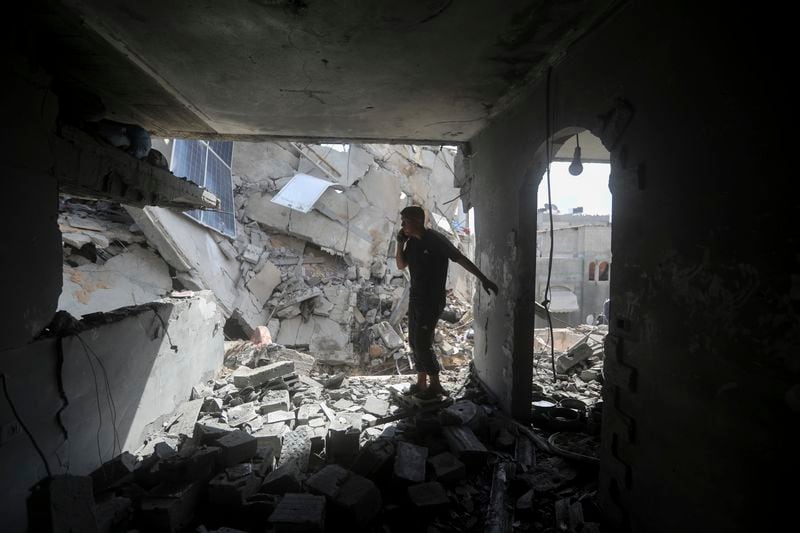 A Palestinian looks at the destruction after an Israeli strike today in Gaza on a residential building in Rafah.