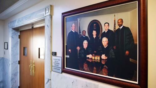 A portrait of the current Georgia Supreme Court justices hangs outside the courtroom Thursday, Feb. 18, 2016, in Atlanta. The Georgia House has approved Gov. Nathan Deal's proposal to add two justices to the state's Supreme Court. Georgia's Constitution permits up to nine justices; state law currently provides for seven justices. The measure now will be reviewed by the state Senate. (AP Photo/David Goldman)
