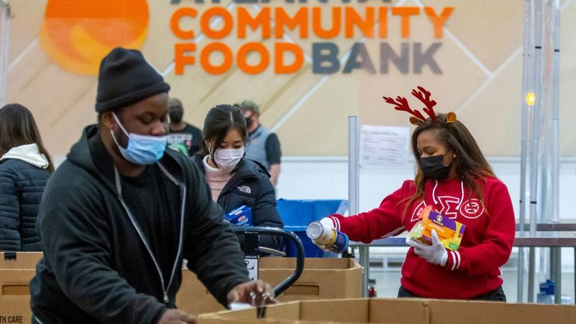 Volunteer Honour Wai Williams (R) sorts food into their appropriate boxes at the Atlanta Community Food Bank Thursday, 23, 2021.    STEVE SCHAEFER FOR THE ATLANTA JOURNAL-CONSTITUTION