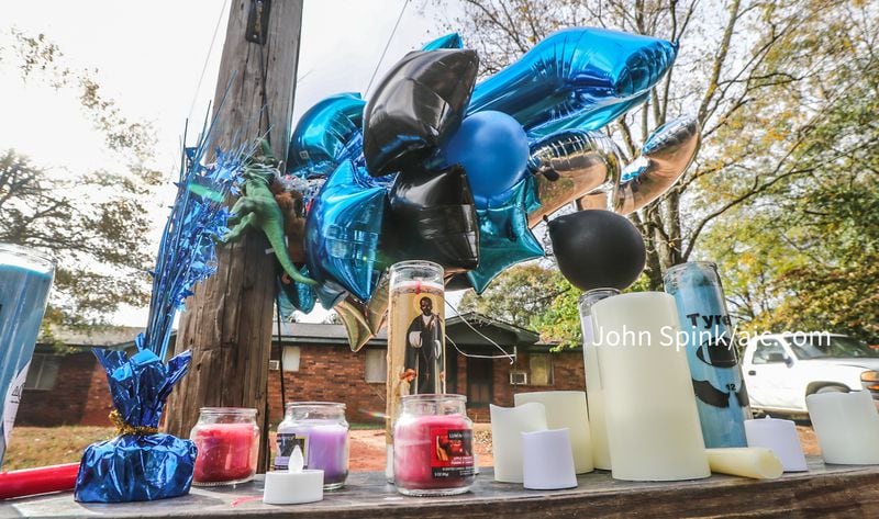 A memorial grows outside a home on Bell Avenue in East Point where 11-year-old Tyrell Sims was killed Friday evening.