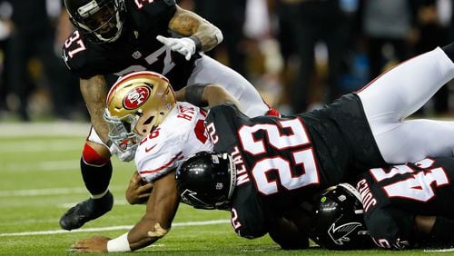 The 49ers' Carlos Hyde is tackled by Falcons Ricardo Allen (37), Keanu Neal (22) and Deion Jones (45) during the second half at the Georgia Dome Sunday, Dec. 18, 2016, in Atlanta.