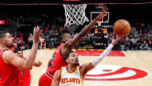 Atlanta Hawks guard Trae Young (11) puts up a shot against the Chicago Bulls' Ayo Dosunmu (12) Thursday, March 3, 2022, in Atlanta. (AP Photo/John Bazemore)
