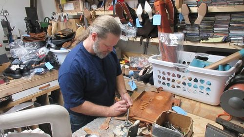 Ryan Embry of Classic Shoes & Repairs works on a well-worn purse. Courtesy of Ryan Embry