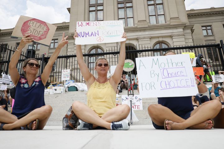 L-R, Misty Whittaker, Maike Caudle, and Casey Key react as a car honk outside the Georgia State Capitol, where abortion rights activists rally to protest the  U.S. Supreme Court's overturning of Roe v Wade. Sunday, June 26, 2022. Miguel Martinez /miguel.martinezjimenez@ajc.com 