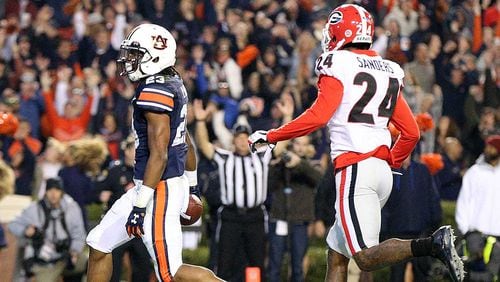 Auburn wide receiver Ryan Davis scores a touchdown past Georgia safety Dominick Sanders to take a 30-7 lead during the third quarter in a NCAA college football game at Jordan-Hare Stadium on Saturday, November 11, 2017, in Auburn. Curtis Compton/ccompton@ajc.com