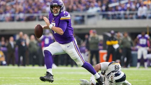 Minnesota Vikings quarterback Case Keenum (7) scrambles in the second quarter against the Los Angeles Rams defensive lineman Aaron Donald (99) at U.S. Bank Stadium.