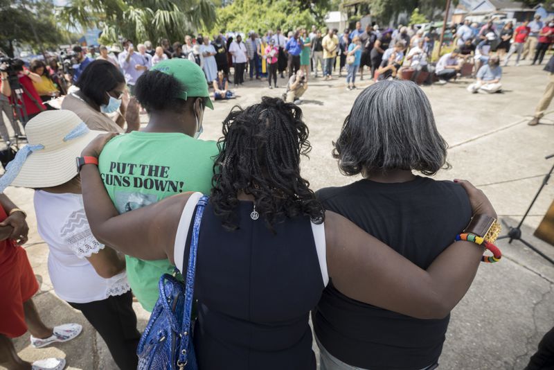BRUNSWICK, GA - AUGUST, 9, 2022: Friends and supporters of Ahmaud Arbery bow their heads in prayer during an event dedicating a downtown street to the 25-year-old Black man who was fatally shot during an afternoon jog two years ago. (AJC Photo/Stephen B. Morton)