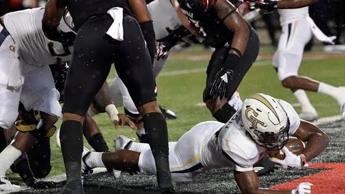 Georgia Tech running back Jordan Mason (24) busts through the Louisville line to score a touchdown during the first half of an NCAA college football game, Friday, Oct. 5, 2018, in Louisville, Ky. (AP Photo/Timothy D. Easley)