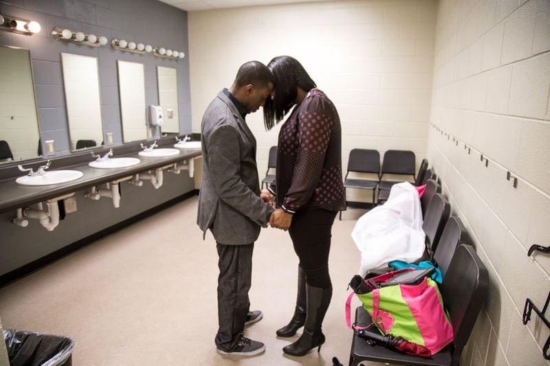 Pastor Lee May and his wife Robin take a moment to pray in the dressing room before the start of the Sunday service of Transforming Faith Church at Southwest DeKalb High School on Oct. 29, 2017. STEVE SCHAEFER / SPECIAL TO THE AJC