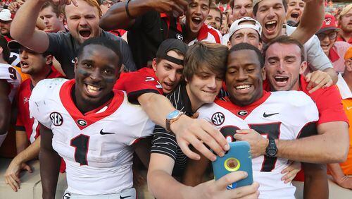 Georgia tailbacks Sony Michel (left) and Nick Chubb celebrate a 41-0 victory over Tennessee with fans at Neyland Stadium in Knoxville, Tennessee Saturday. (Curtis Compton/ccompton@ajc.com)