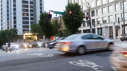 Pedestrians and cars pass through Peachtree on Sunday, July 9, 2023 in Atlanta. (Michael Blackshire/Michael.blackshire@ajc.com)