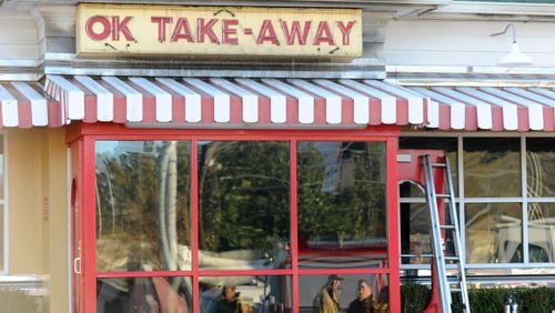 Fire fighters are reflected in the takeout window as they investigate a blaze at the OK Cafe restaurant during the morning breakfast rush on Sunday, Dec. 7, 2014, in Atlanta. (AJC Special/David Tulis)