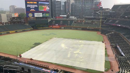 The outfield at Truist Park takes on a white cast during a hail storm prior to a baseball game between the Atlanta Braves and the Arizona Diamondbacks, Saturday, April 24, 2021, in Atlanta. Thunderstorms were were forecast in Atlanta in the early evening. (AP Photo/Ben Margot)