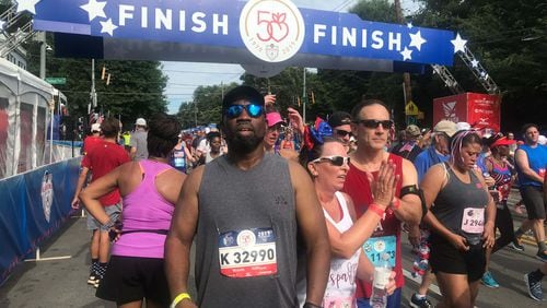 Willie Hatchett (in gray shirt) near the finish line of the 50th running of The Atlanta Journal-Constitution Peachtree Road Race on July 4, 2019. Three years later, Hatchett went into cardiac arrest about a mile into the running of the race. He received quick help from a police officer and three physicians. He survived and has plans to run in the 2023 AJC Peachtree Road Race. (Photo contributed by Willie Hatchett)