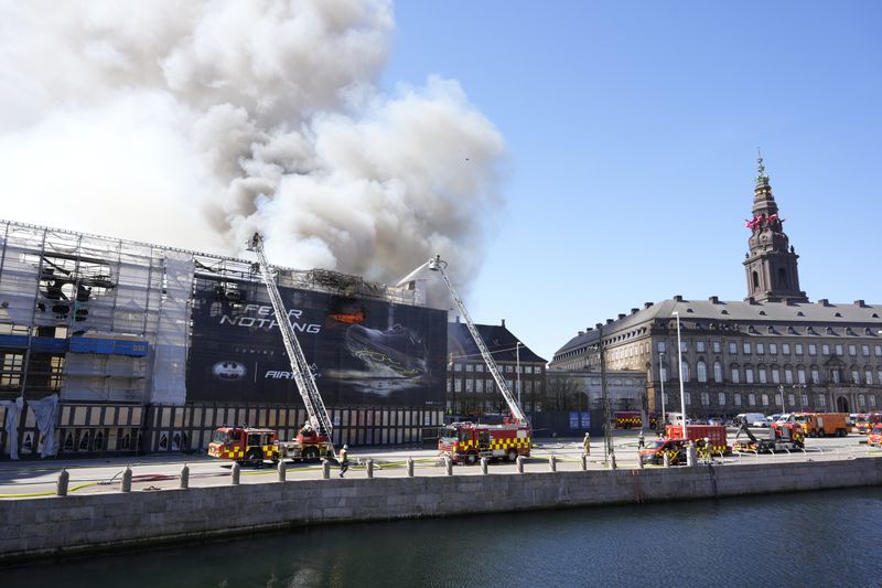 Firefighters work as smoke rise out of the Old Stock Exchange, Boersen, in Copenhagen, Denmark, Tuesday, April 16, 2024. One of Copenhagen’s oldest buildings is on fire and its iconic spire has collapsed. The building, which is situated next to the Christiansborg Palace where the parliament sits, is a popular tourist attraction. Its distinctive spire, in the shape of the tails of four dragons twined together, reached a height of 56 meters (184 feet). (Emil Helms/Ritzau Scanpix via AP)