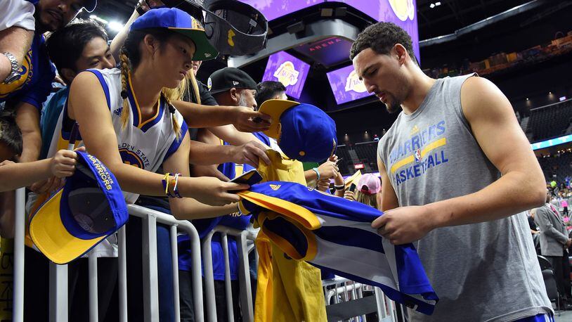 The Golden State Warrior's Klay Thompson signs autographs for young fans.
