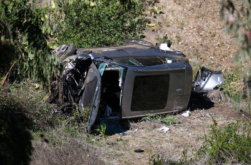 A vehicle rests on its side after a rollover accident involving golfer Tiger Woods along a road in the Rancho Palos Verdes section of Los Angeles. Woods suffered leg injuries in the one-car accident and underwent surgery, authorities and his manager said. (AP Photo/Ringo H.W. Chiu)
