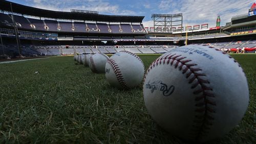 Baseballs line the field for batting practice while the Braves prepare to play their final game at Turner Field on Sunday, Oct. 2, 2016, in Atlanta.