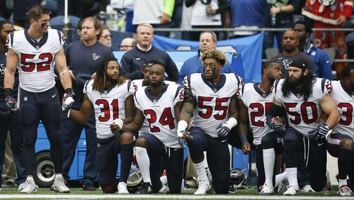 Members of the Houston Texans stand and kneel before the game last month against the Seattle Seahawks. (Photo by Otto Greule Jr/Getty Images)