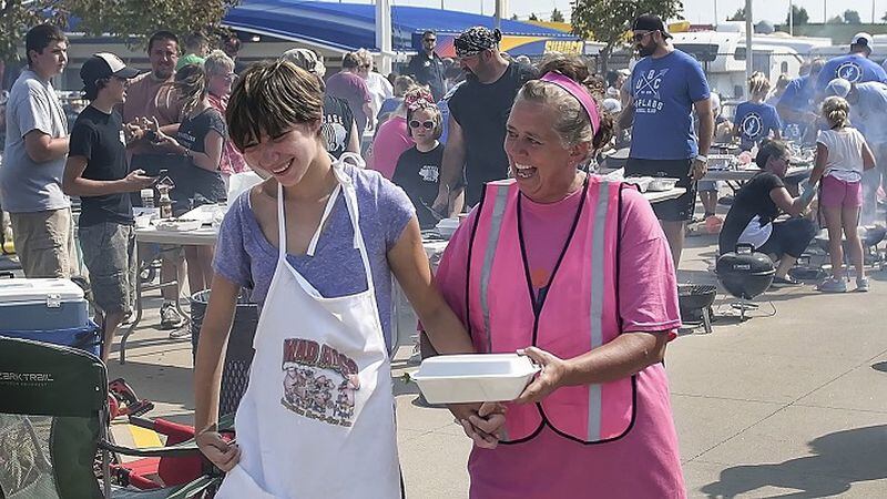 Allison Verman, right, helps walk Madeline Boschert, left, with her barbequed shrimp competition entry in hand to the judges during the 11th annual Kids Que competition at the American Royal at Kansas Speedway. (David Eulitt/Kansas City Star/TNS)