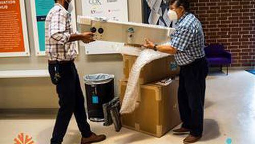Faizan Aly, managing director (L) and Co-founder of Aguair Itamar Kleinberger unpacking the donated equipment, their SaniCart and the ClensAir.