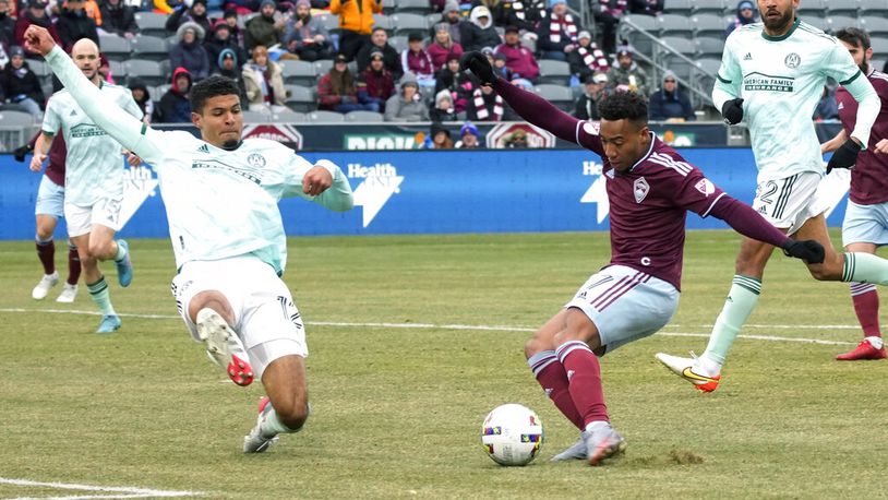 Colorado Rapids' Jonathan Lewis, right, kicks the ball as Atlanta United's Miles Robinson defends during the first half of an MLS soccer match Saturday, March 5, 2022, in Commerce City, Colo. (AP Photo/David Zalubowski)
