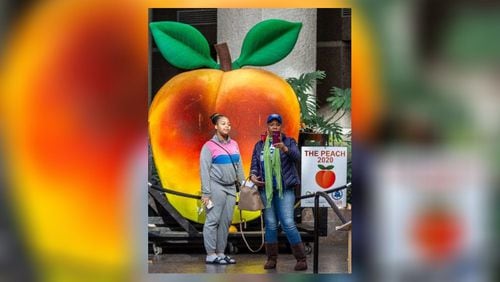 Joya Poole and her granddaughter Kayla Hays take a selfie in front of the peach from Atlantaâ€™s annual Peach Drop in the atrium of the Fulton County Government Center December 31, 2019. STEVE SCHAEFER / SPECIAL TO THE AJC