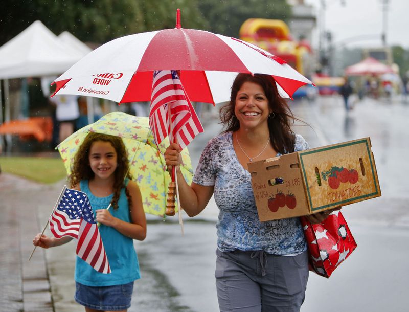 Doreen Row (right) and her daughter, Rachel, 8, didn't let the weather dampen their spirits. Rain dampened the turnout for the 22nd annual Marietta Streetfest held on the Marietta Square Saturday. The event is a fundraiser for the Marietta Museum of History and featured antique dealers and artists, the Marietta Square Farmers Market, the Hubcaps and History Marietta Classic Car Show and the Marietta Grassroots Music Festival.