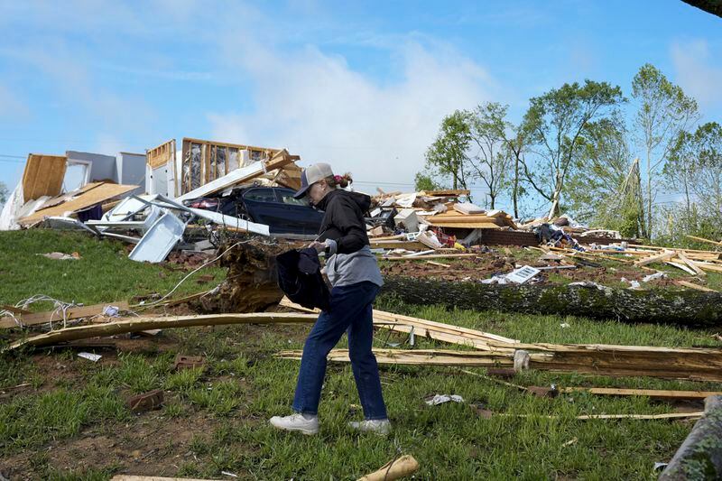 Valerie Bernhardt searches for belongings outside her stormed damaged home Thursday, May 9, 2024, in Columbia, Tenn. Severe storms tore through the central and southeast U.S., Wednesday, spawning damaging tornadoes, producing massive hail, and killing several people in Tennessee. (AP Photo/George Walker IV)