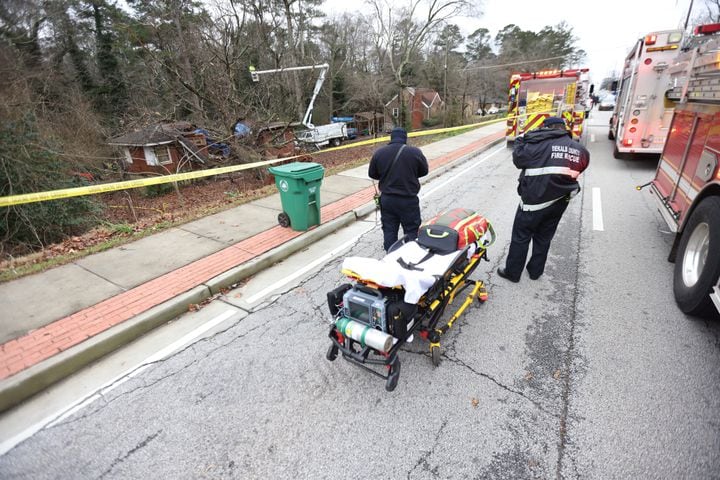 Paramedics from the Dekalb County Fire Department observe the clean-up process if an accident occurs where a tree fell on the house, killing a 5-year-old boy. His mother was rescued and later taken to the hospital on Monday, January 3, 2022. Miguel Martinez for The Atlanta Journal-Constitution