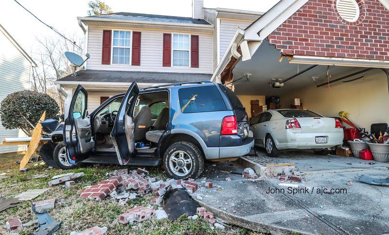A blue Ford SUV was stolen a short time before the driver crashed into the front of this Browns Mill Ferry Home. JOHN SPINK / JSPINK@AJC.COM