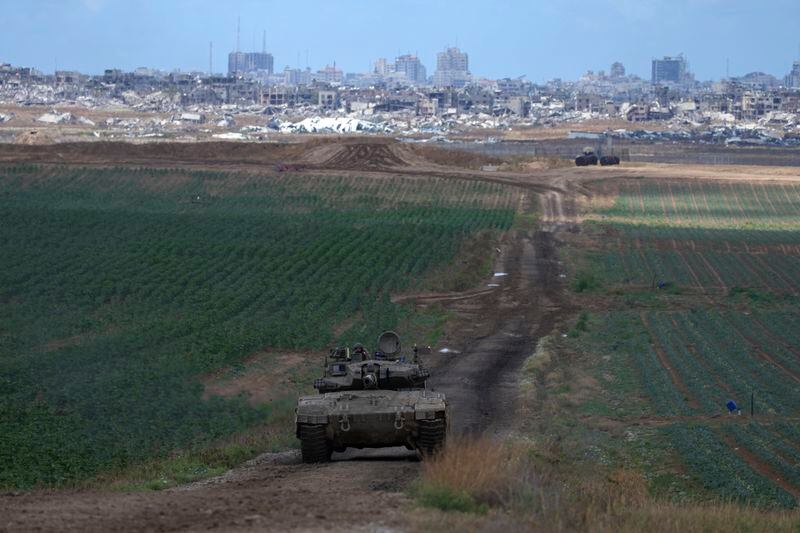 An Israeli Defense Forces tank drives away from the Gaza Strip, as seen from southern Israel, Monday, May 6, 2024. (AP Photo/Tsafrir Abayov)