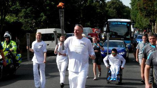 Jon McCullough, a two-time Paralympian and executive director of BlazeSports, carries the torch during the 2012 Summer Paralympics in London, England.