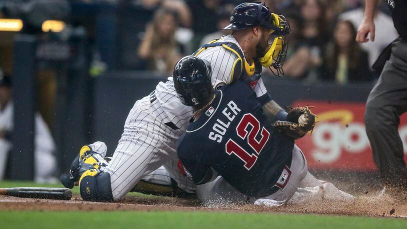 Braves right fielder Jorge Soler  is tagged out at the plate by Brewers catcher Omar Narvaez during the first inning of National League Division Series Game 1 on Friday in Milwaukee. Curtis Compton / Curtis.Compton@ajc.com