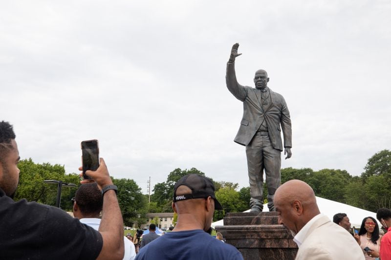 A visitor takes of photo of the new John Lewis statue at Rodney Cook Sr. Park in Vine City in Atlanta on June 7, 2021. (Photo/ Jenn Finch for The Atlanta Journal Constitution)