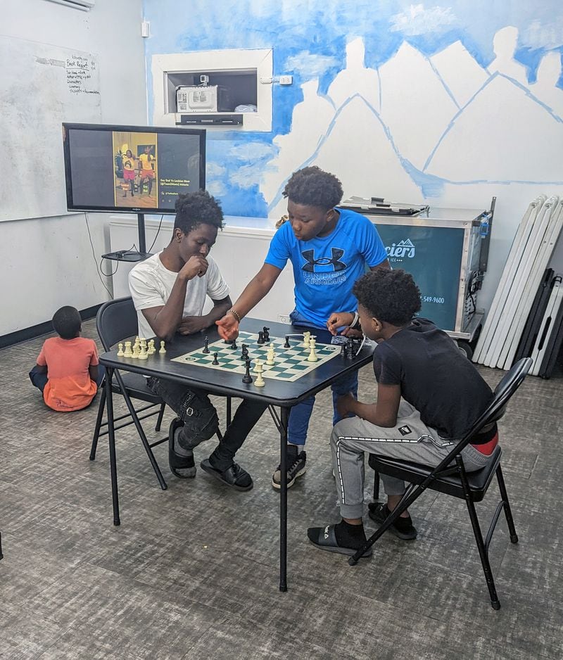 Christopher Brown (left) and two other kids play chess at Glaciers Italian Ice on Thursday, May 11, 2023. (Mirtha Donastorg / Mirtha.Donastorg@ajc.com)