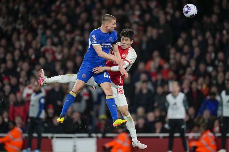 Chelsea's Alfie Gilchrist, left, jumps for the ball with Arsenal's Takehiro Tomiyasu during the English Premier League soccer match between Arsenal and Chelsea at Emirates Stadium in London, Tuesday, April 23, 2024. (AP Photo/Kin Cheung)
